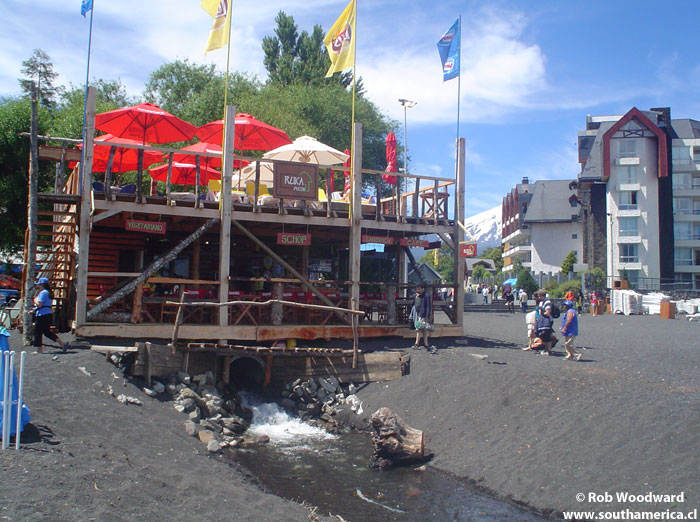 A shop with a stream running underneath it on the beach of Pucón